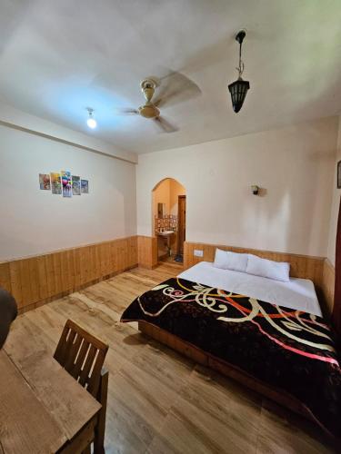 a bedroom with a bed and a ceiling fan at PREMALYA TRAILS By Tirtha in Nagar