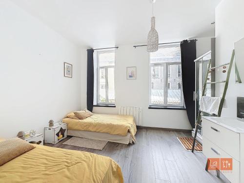 Cette chambre blanche comprend 2 lits et 2 fenêtres. dans l'établissement Mahon - Centre ville, à Boulogne-sur-Mer