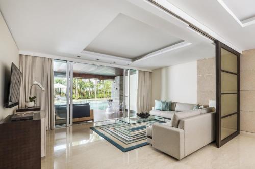 a living room with a couch and a table at COMO Uma Canggu in Canggu
