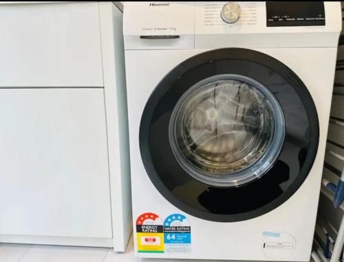 a washing machine with its door open in a kitchen at Leppington Two-Level 4Br near Village & Woolworths in Leppington