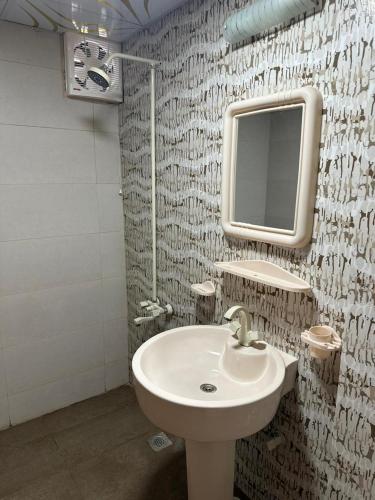 a bathroom with a sink and a mirror at The Red Tree Family Guest House in Karachi