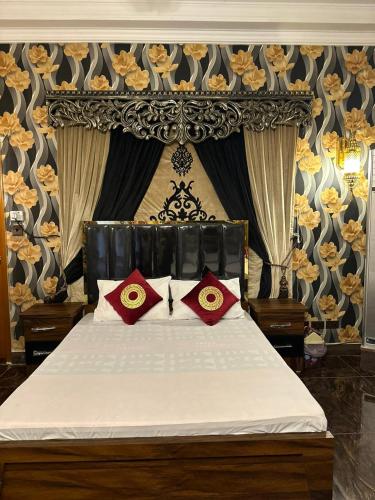 a bedroom with a bed with red pillows on it at The Red Tree Family Guest House in Karachi