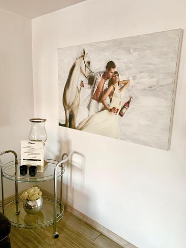 a painting of a bride and groom and a horse on a wall at Perfect Stay - "Campari Glam Apartments" in Toruń