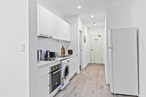 a kitchen with white cabinets and a washer and dryer at Burwood 1Br apt nearTrainShopping street parking in Sydney