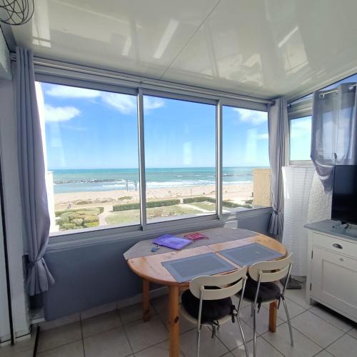 une salle à manger avec une table et une vue sur la plage dans l'établissement Studio les pieds dans l'eau App n°7, au Barcarès
