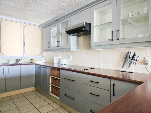 a kitchen with white cabinets and a counter top at Beachcombers 13 in Ballito
