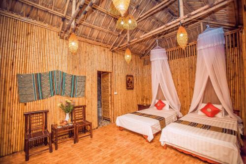 a bedroom with two beds in a room at Tam Coc Rice Fields Resort in Ninh Binh