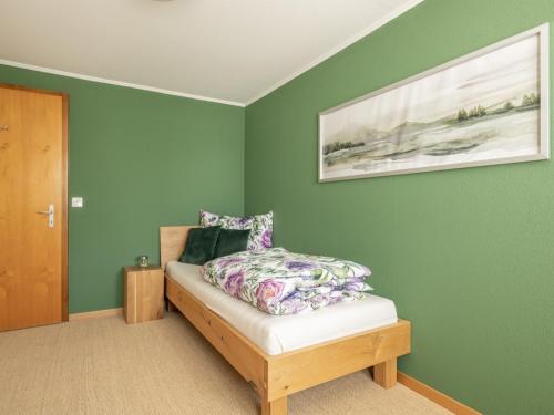 a bedroom with green walls and a bed with a pillow at Berggasthaus Holzegg - Accessible Only by Cable Car in Alpthal