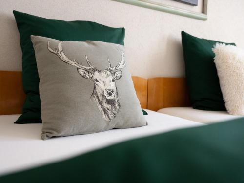 a cushion with a deer head on a bed at Berggasthaus Holzegg - Accessible Only by Cable Car in Alpthal