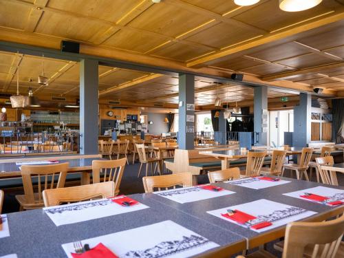 a dining room with tables and chairs in a restaurant at Berggasthaus Holzegg - Accessible Only by Cable Car in Alpthal