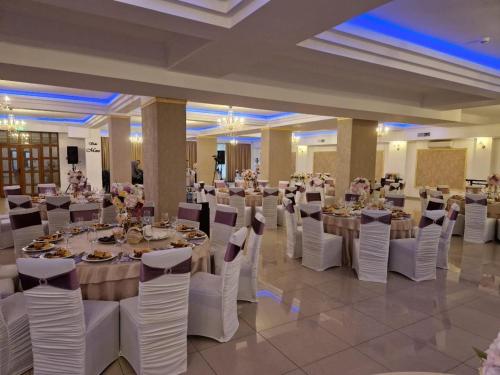 a banquet hall with white tables and white chairs at Hotel Rao in Cluj-Napoca