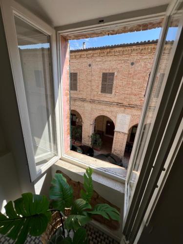 a window with a view of a brick building at CASA NINETTA GUEST HOUSE in Urbisaglia
