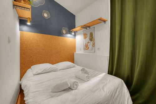 une chambre avec un lit blanc avec des serviettes dessus dans l'établissement Appartement Cosy - Terrasse - Proche Métro, à Toulouse