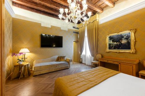a bedroom with a bed and a couch and a chandelier at Palazzo dei Mori in Venice
