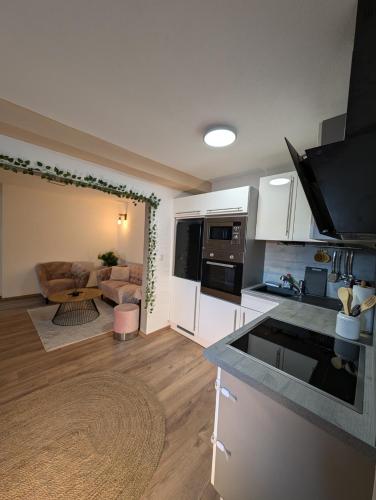 a kitchen with white cabinets and a living room at Privatunterkunft in Göppingen in Göppingen