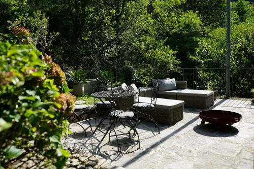 a patio with a table and chairs and a couch at La Bolla Verde Lake Como in Lecco