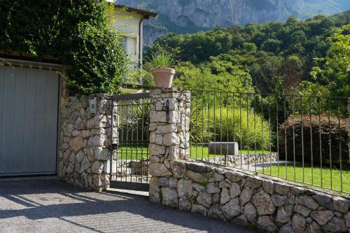 a stone fence with a gate in front of a house at La Bolla Verde Lake Como in Lecco