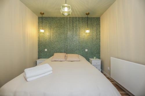 a bedroom with a white bed with two pillows at Le Cosy - Appartement avec Jardin Wimille proche Wimereux in Wimereux