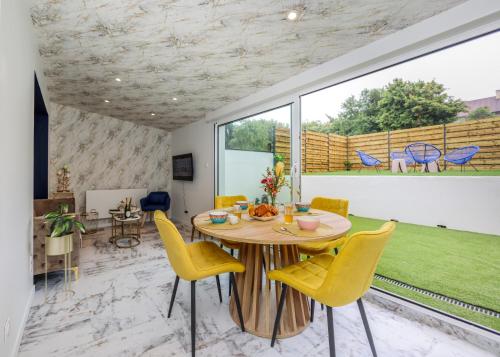 une salle à manger avec une table et des chaises jaunes dans l'établissement Le Cosy - Appartement avec Jardin Wimille proche Wimereux, à Wimereux