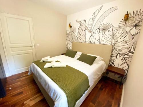 - une chambre avec un grand lit et une couverture verte et blanche dans l'établissement Mazet Cordelles Alpilles, à Eygalières