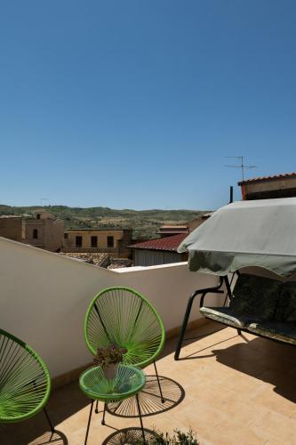 a balcony with two chairs and an umbrella at La Martina Home in Valguarnera Caropepe