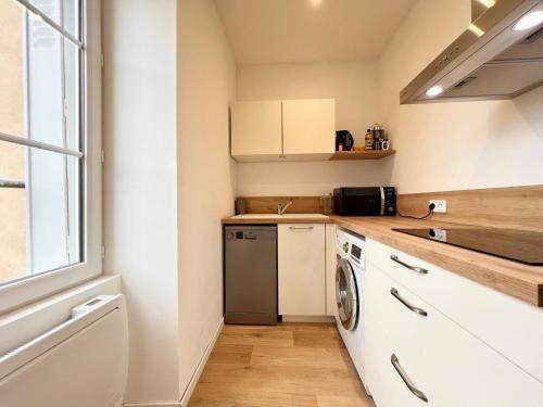 une petite cuisine avec un lave-linge et un sèche-linge. dans l'établissement La parenthèse Pictave - centre-ville de Poitiers, à Biard