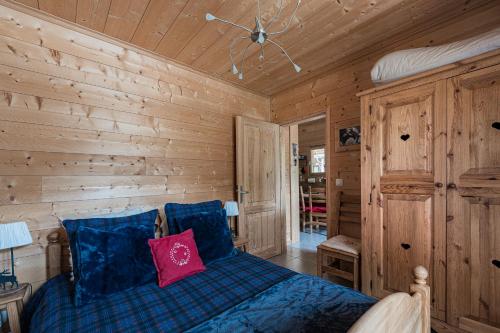 une chambre avec un lit dans une cabane en rondins dans l'établissement Appartement Andromède 25 minutes de Chamonix, à Saint-Gervais-les-Bains
