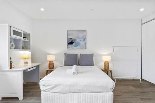 a white bedroom with a white bed and a desk at Burwood 1Br studio nearTrain StationShopping in Sydney