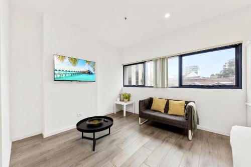 a living room with a couch and a table at Burwood 1Br studio nearTrain StationShopping in Sydney