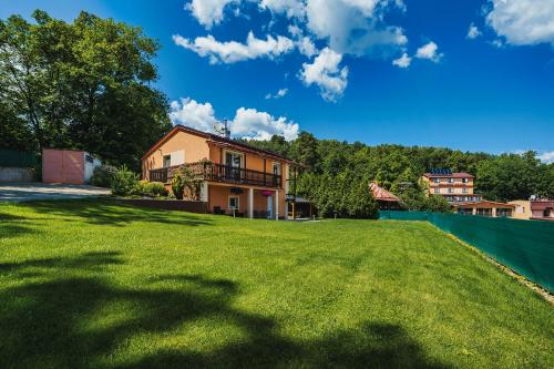 a large yard with a house in the background at Chata Maxim Bojnice in Bojnice