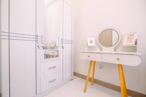 a white bathroom with a sink and a mirror at Comfort and Nice 2BR at Tokyo Riverside PIK 2 Apartment By Travelio in Rawalembang