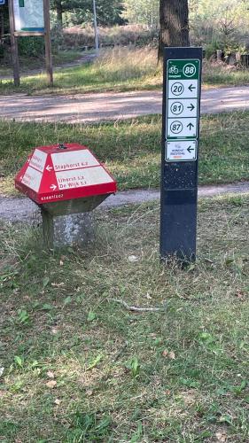 a sign sitting in the grass next to a street at SAYANG26 gezellige gezinsvriendelijke stacaravan op familiecamping De Vossenburcht in natuurgebied Reestdal - no workers allowed in IJhorst