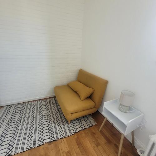 une chaise brune dans un coin avec une table dans l'établissement Appartement cosy proche Paris, à Colombes