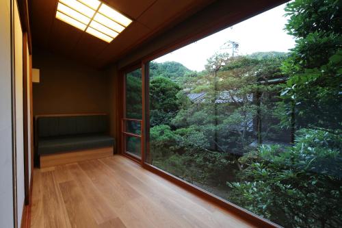 a room with a large window and a couch at Nishimuraya Honkan in Toyooka