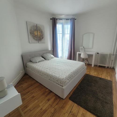 une chambre blanche avec un lit et une fenêtre dans l'établissement Appartement cosy proche Paris, à Colombes
