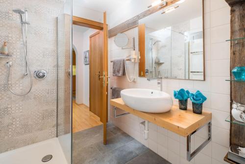 a bathroom with a sink and a shower at Das Bäckergut am Haldensee in Haldensee