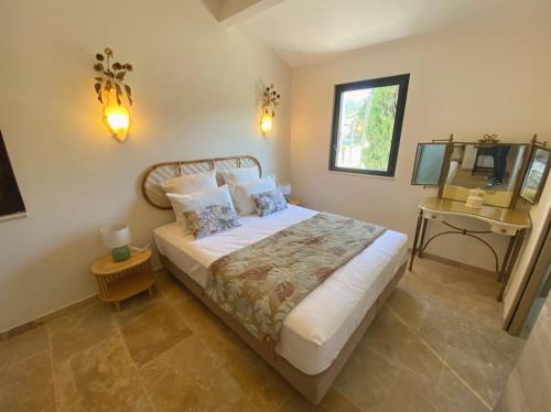 une chambre avec un grand lit et un miroir dans l'établissement Mazet avec piscine, à Saint-Rémy-de-Provence