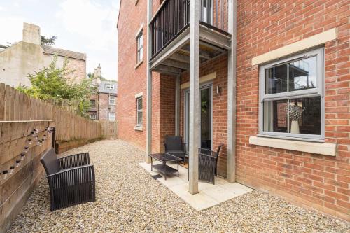a brick building with two chairs and a table at Host & Stay - Shipwright Lodge in Whitby