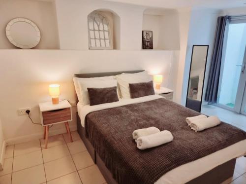 a bedroom with a large bed with towels on it at Evo B - 1 Bedroom Flat 2 Min Walk to Station & Town Centre in Gravesend