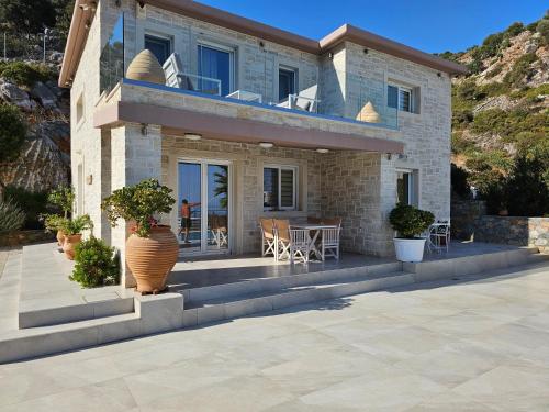 a house with a patio with a table and chairs at Villa petros in Malia