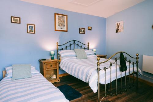 two beds in a bedroom with blue walls at New Inn Lodge In Scarning Near Dereham Norfolk England in East Dereham