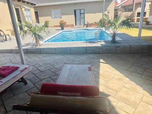 a patio with a couch and a swimming pool at Horizon Bed and Breakfast in Roodepoort