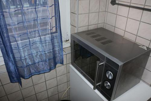 un forno a microonde in una cucina con una tenda blu di Drei Zi App nahe Limbecker Platz und Uni a Essen