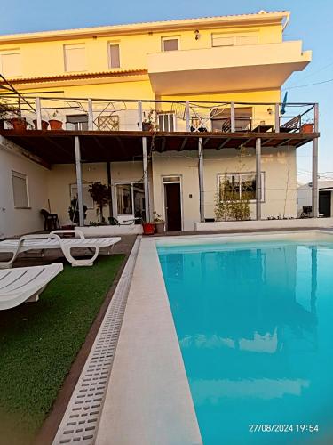 a house with a swimming pool next to a building at Seixal Bay Village - Family Choice in Seixal