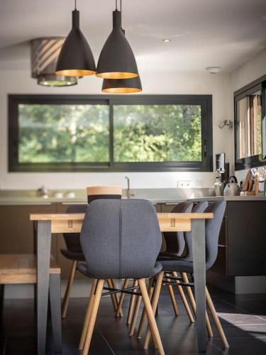 une cuisine avec une table en bois, des chaises et une fenêtre dans l'établissement Venez Chez Vous Villa Nature, à Alex