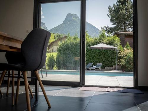une chaise dans une chambre avec vue sur la piscine dans l'établissement Venez Chez Vous Villa Nature, à Alex