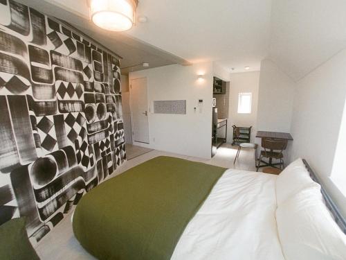 a bedroom with a green and white bed in a room at The Aoca Tokyo Kaminoge in Tokyo