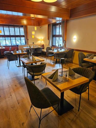 a restaurant with tables and chairs in a room at PLAZA INN Recklinghausen in Recklinghausen