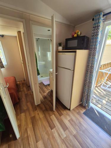 une petite pièce avec un réfrigérateur et un micro-ondes dans l'établissement Camping les Peupliers, à Vendays-Montalivet