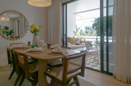a dining room with a table and a mirror at Monsoon Luxury Apartment in Port Douglas